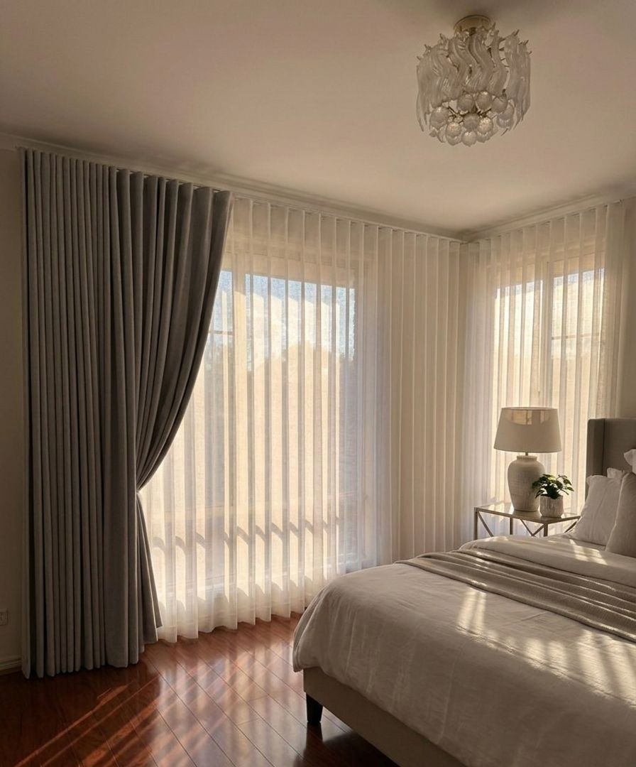 Grey blockout and white sheer curtains in a sunlit bedroom